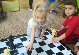Dzieci ustawiają figury szachowe